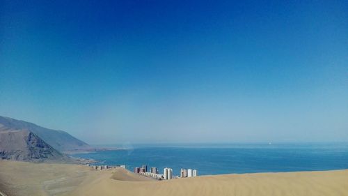 Scenic view of beach against clear blue sky