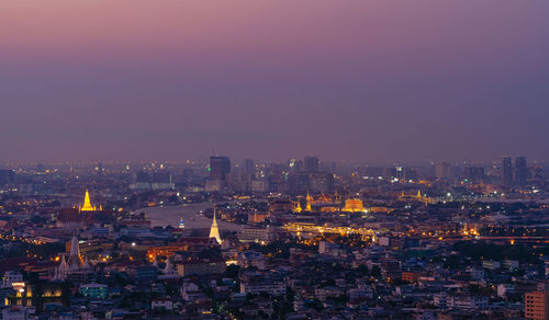 High angle view of illuminated cityscape against sky at night