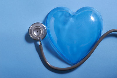 High angle view of stethoscope on blue background