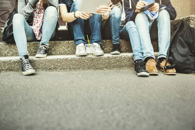 Low section of people sitting on street