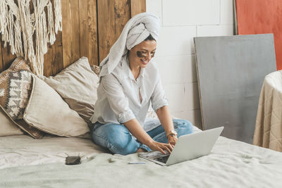 Woman at home on bed makes purchases on the internet. the joy of the black friday sale.