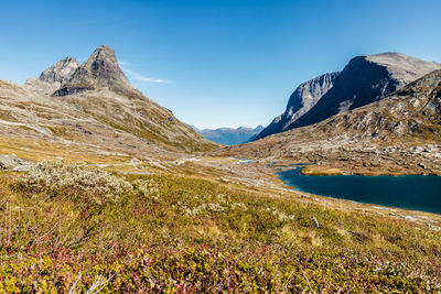 Scenic view of lake and mountains against blue sky