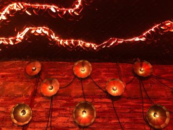 Low angle view of illuminated lighting decoration on wall
