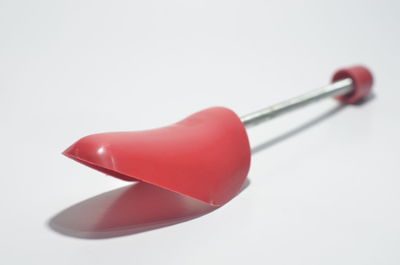 Close-up of red bell over white background