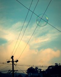 Low angle view of power lines against sky during sunset