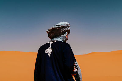 Rear view of women standing against clear sky