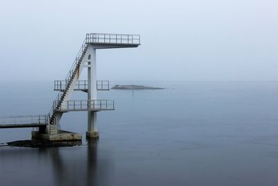 Metal structure in fog against sky