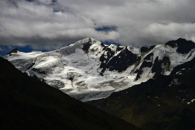 Scenic view of snowcapped mountain against cloudy sky