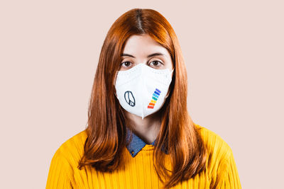 Portrait of woman wearing mask against white background