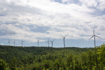 Wind turbines on land against sky