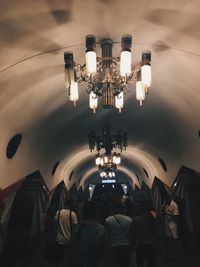 Rear view of people on illuminated ceiling