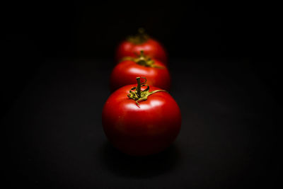 Close-up of red bell peppers against black background