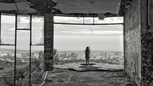 Woman looking down from abandoned building