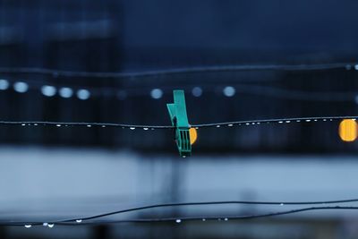 Clothespin hanging on clothesline during rainy season