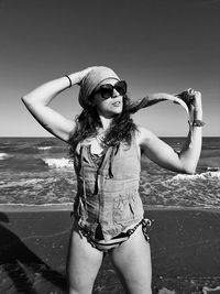 Portrait of young woman standing at beach