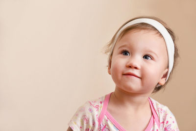 Portrait of cute girl against wall