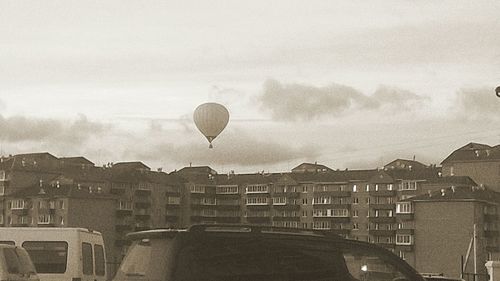 Hot air balloon in city against sky