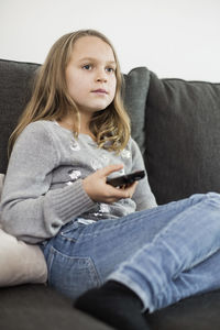 Girl watching tv on sofa at home