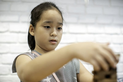 Close-up of girl playing black removal game at home