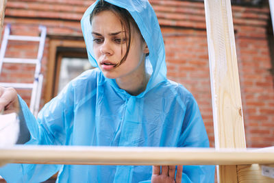 Portrait of young woman standing by railing