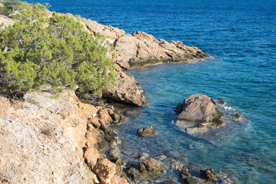 High angle view of rocks on sea shore