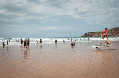 People on beach against sky