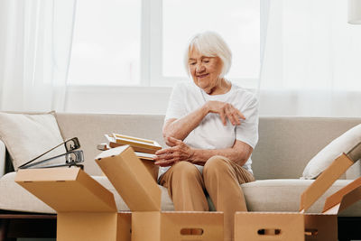 Portrait of woman sitting on sofa at home