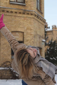 Beautiful caucasian girl with pink mittens on a winter day enjoying nature and having fun