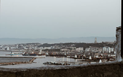 Sailboats in city against clear sky