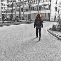 Rear view of woman walking on road