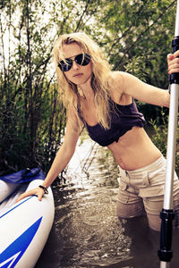 Portrait of mid adult woman wearing sunglasses standing in lake