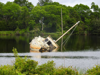 A damaged abandoned sailboat resting in shallow waters