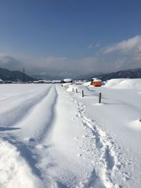 Snow covered landscape against sky