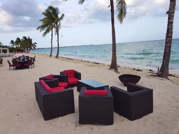 Chairs on beach against sky