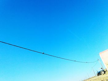 Low angle view of ski lift against clear blue sky