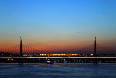 View of suspension bridge in city at sunset