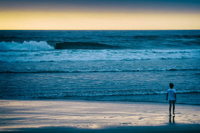 Rear view of man standing on beach