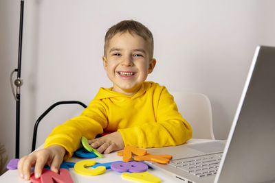 Adorable, cute, little boy learning alphabet online, with laptop at home. child using e-learning