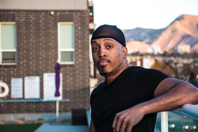 Portrait of man standing against railing in back yard