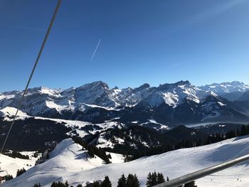 Scenic view of snowcapped mountains against clear blue sky