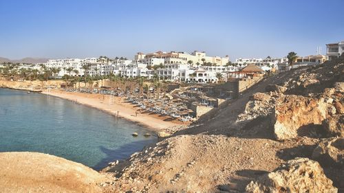 Aerial view of town by sea against clear sky