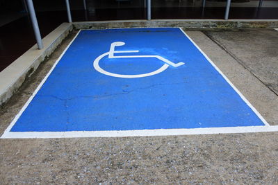 High angle view of blue sign on parking lot