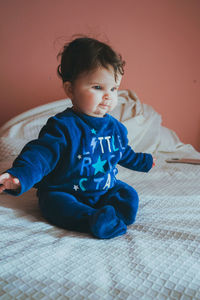 Cute baby girl sitting on bed