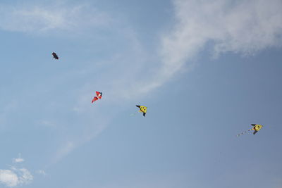 Low angle view of kites flying in sky