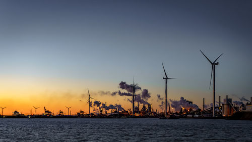 Pollution by tata steel. sunset. reflection of the sun in the sky. smoke from the chimneys.windmill