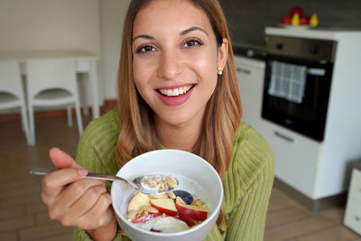 Happy girl eating cereals at home