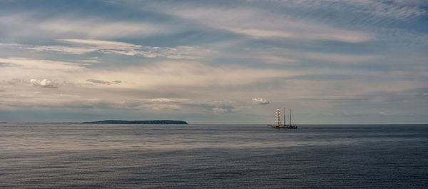 Sailboat sailing on sea against sky