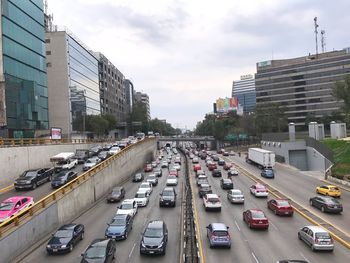 Cars on street in city against sky