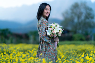 Beautiful young woman standing on field