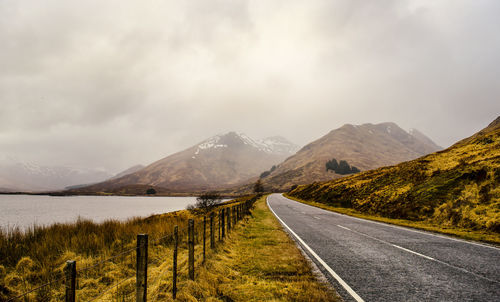 Road amidst mountains against sky